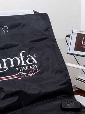Close-up of the black LIMFA Therapy PEMF mat with its head-position marker and paired monitor