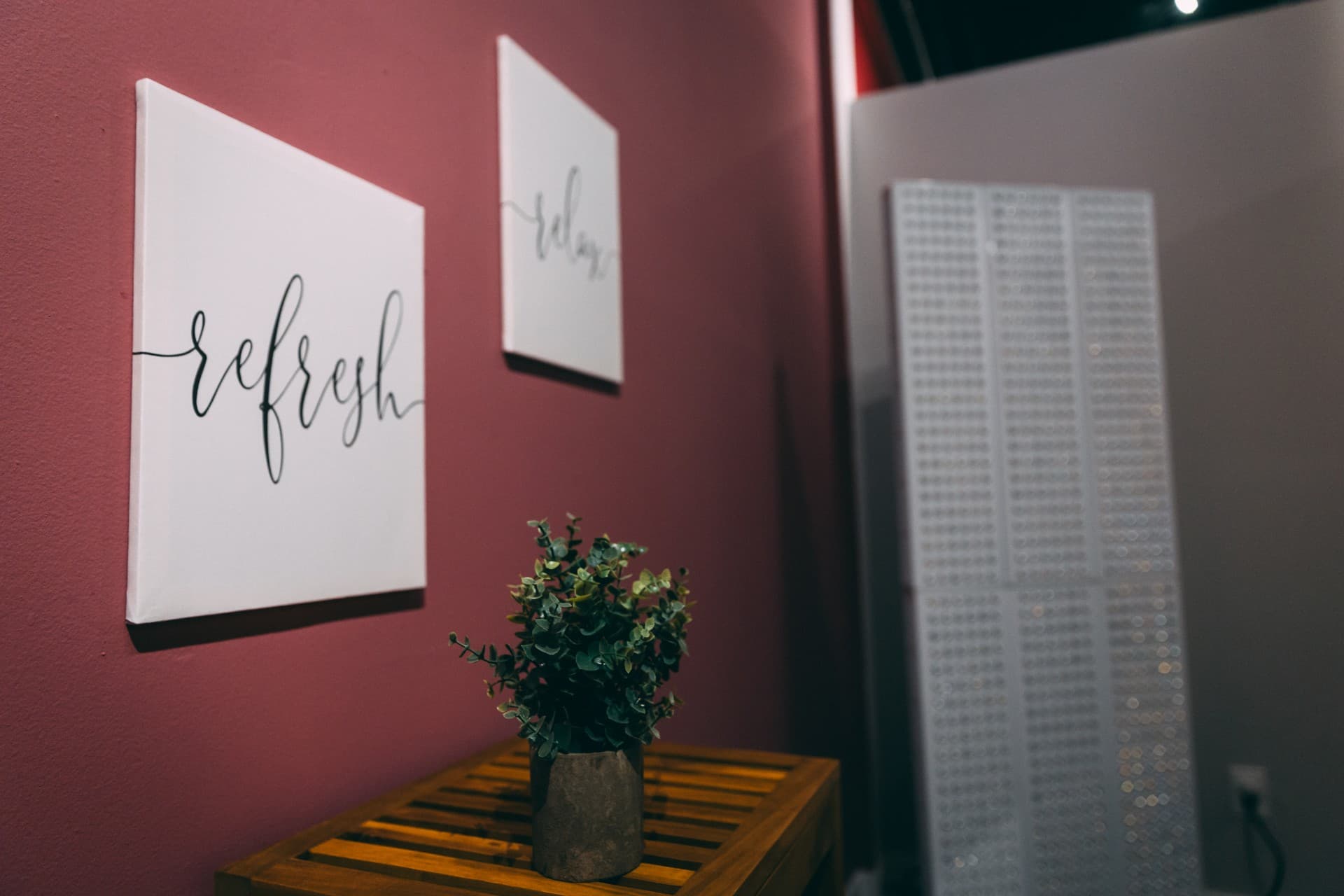 Calming corner with 'refresh' and 'relax' canvas prints and a potted plant against a dusty-rose wall