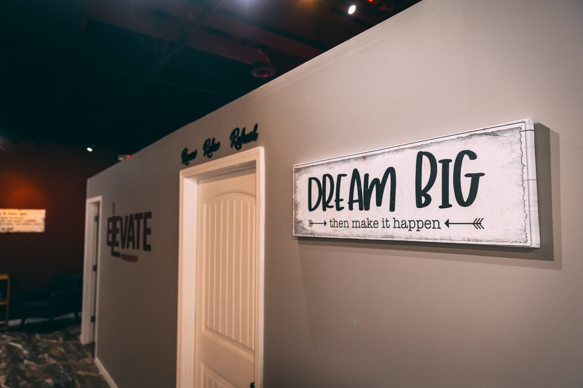 'Dream Big — then make it happen' sign in the studio hallway beside the ELEVATE logo