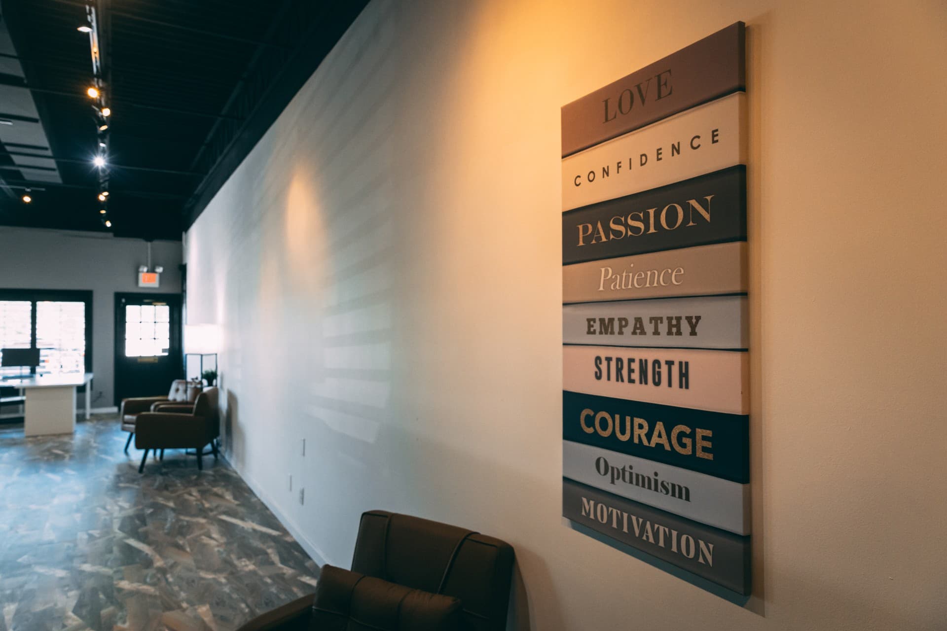 Stacked values panel reading Love, Confidence, Passion, Strength and more along the lounge wall