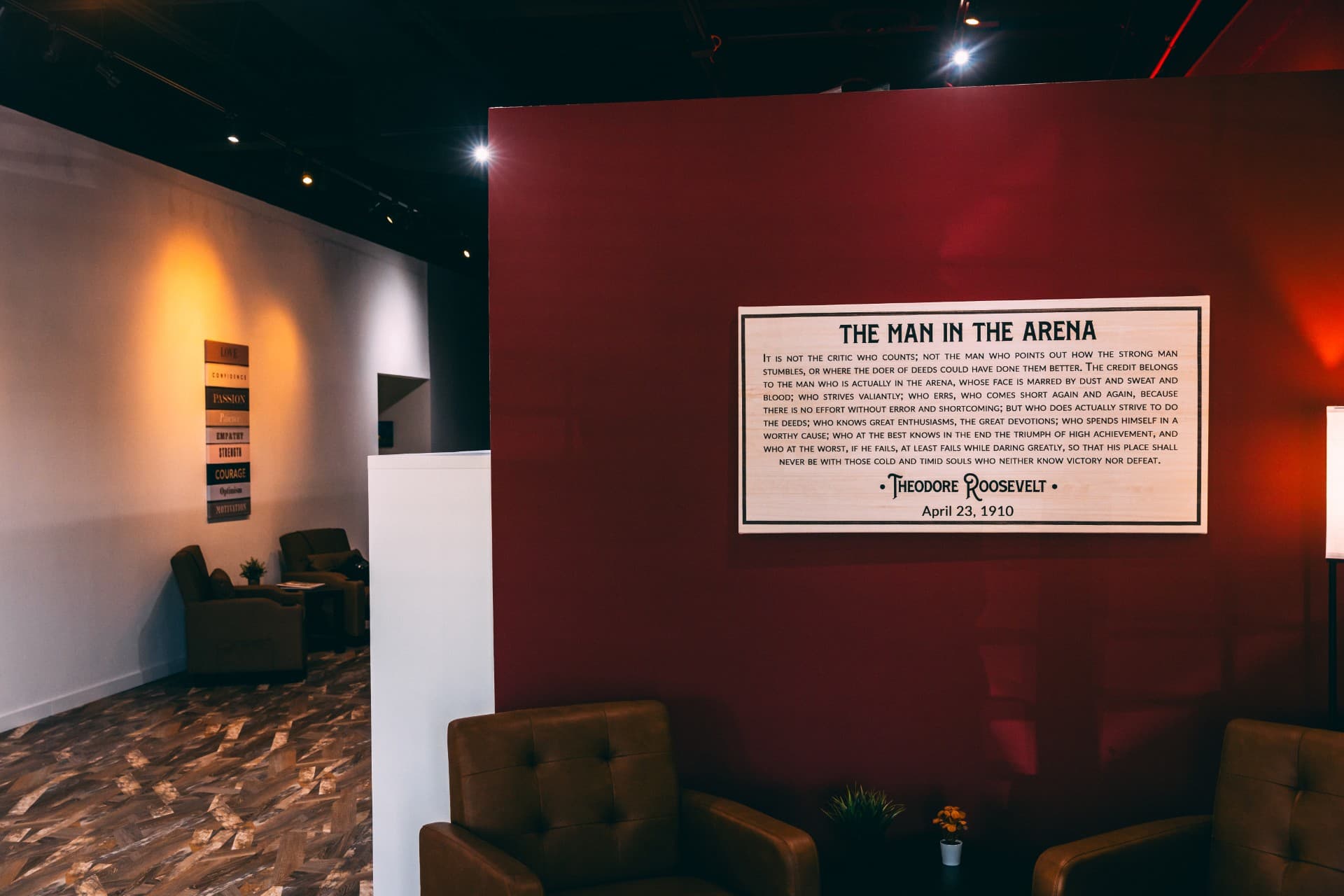 Comfortable lounge seating beside a 'Man in the Arena' wall feature