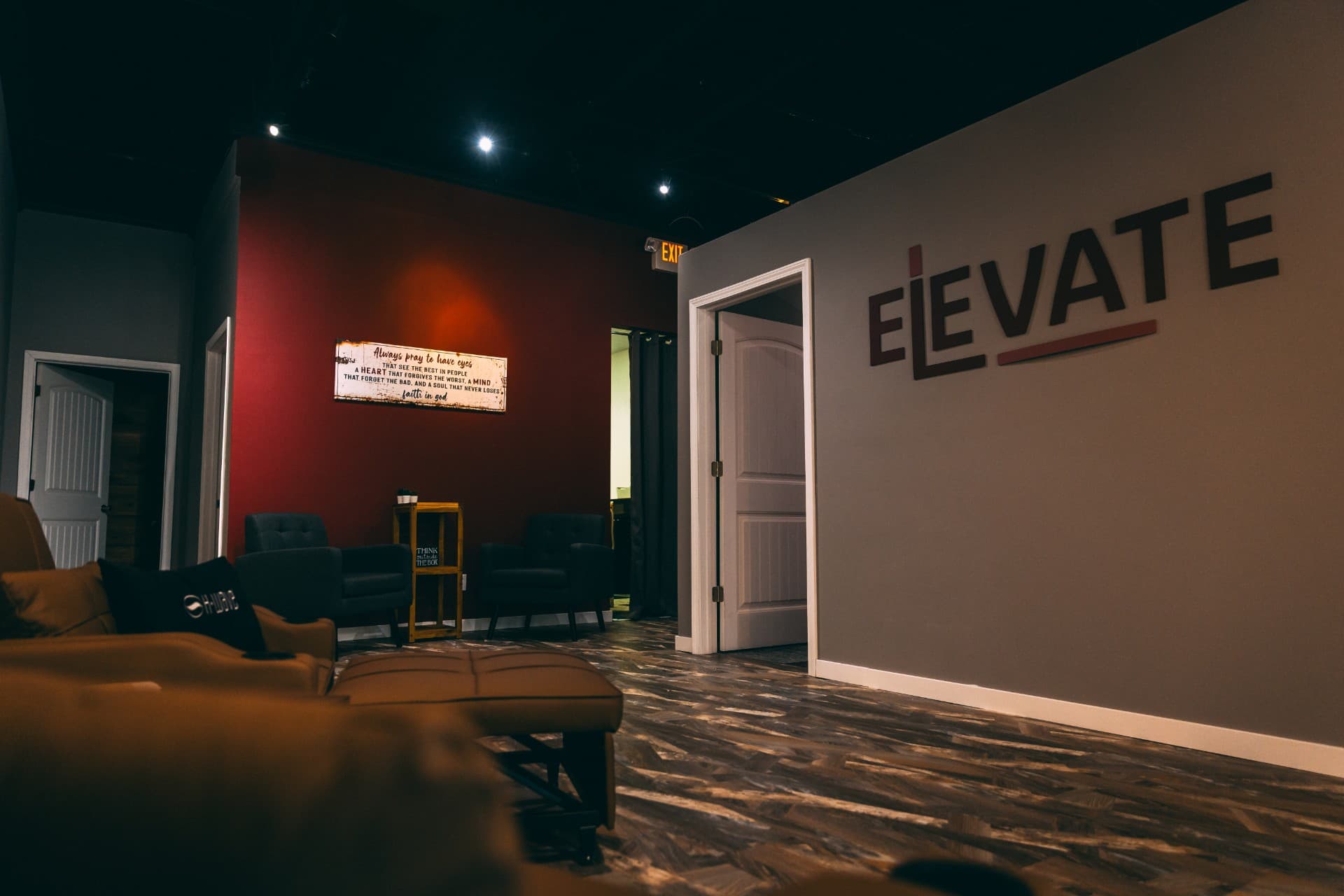 Relaxed lounge area with leather seating and the ELEVATE logo on the wall