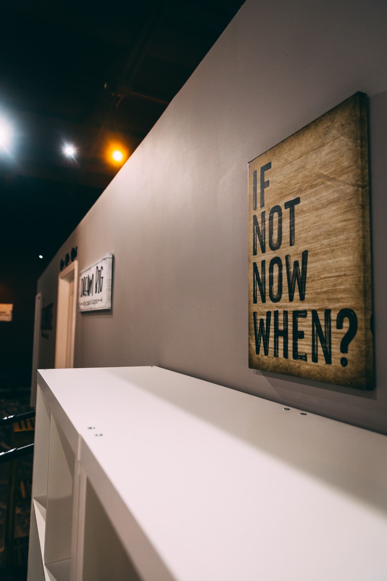 'If not now, when?' wood-panel sign mounted above the studio reception