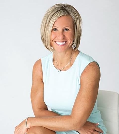Jaime Hughes, founder of Elevate Wellness Studio, smiling in a bright studio portrait