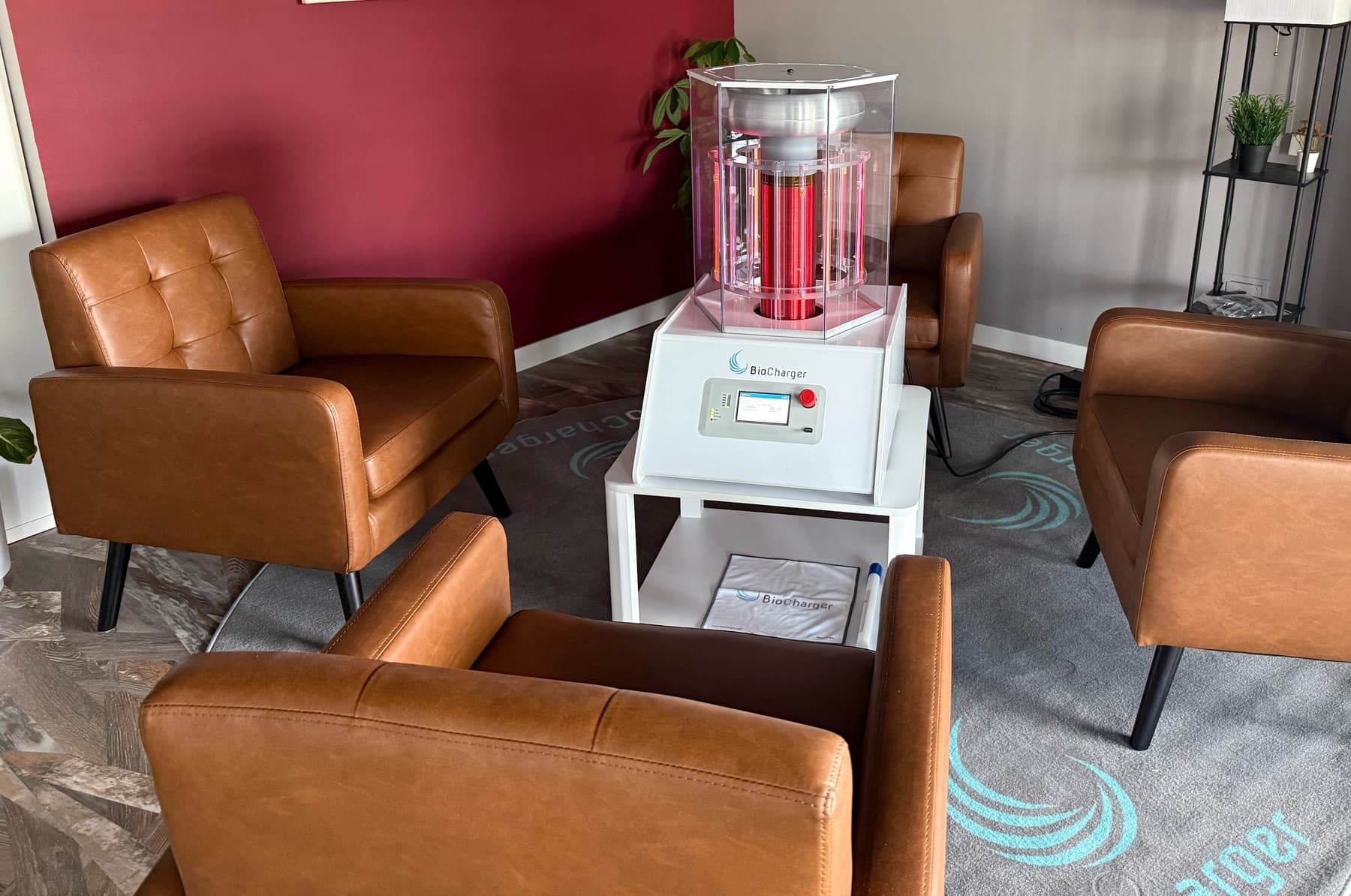 Leather armchairs gathered around the BioCharger in a quiet corner of Elevate Wellness Studio, its coil glowing softly