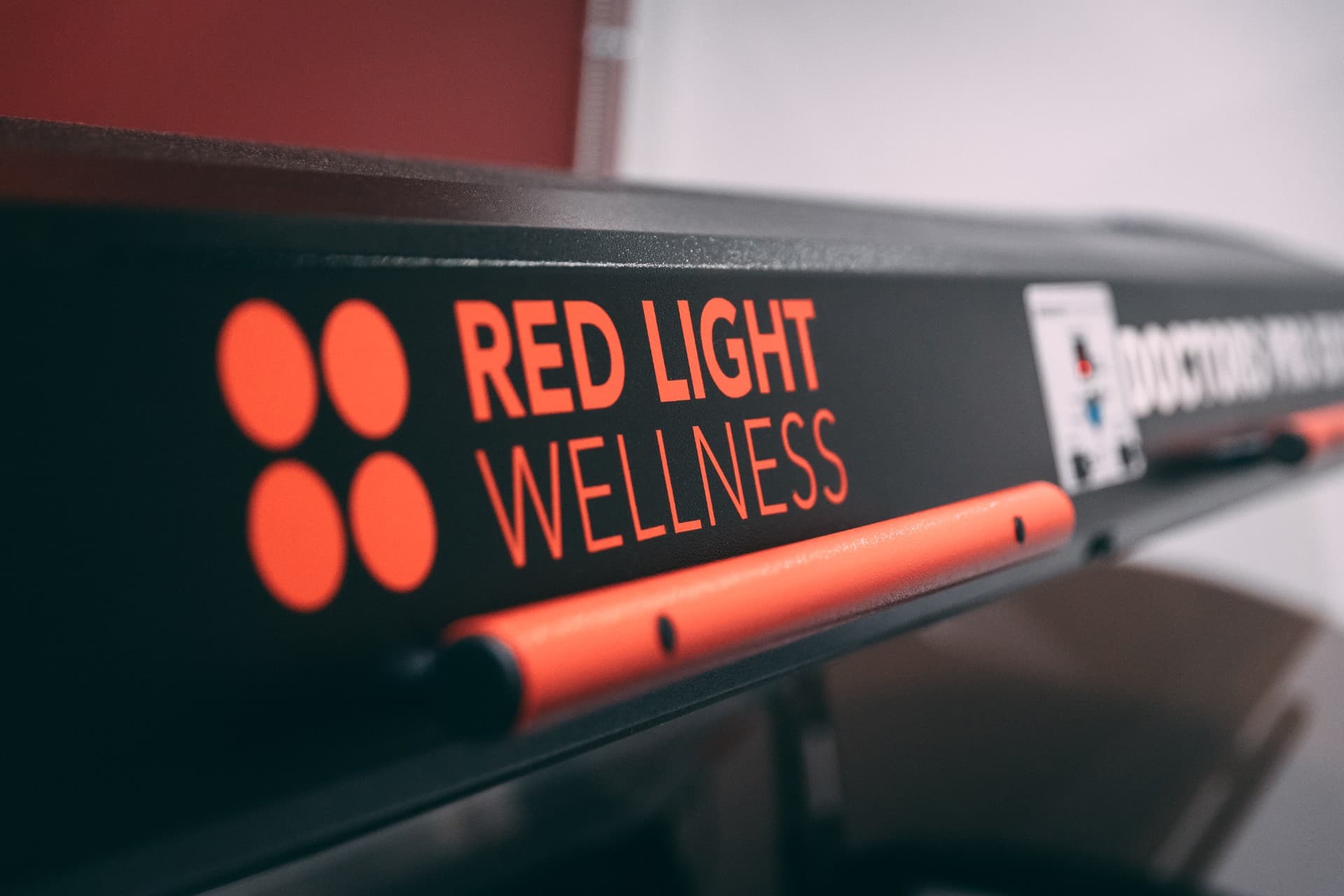 Close-up of the Red Light Wellness branding on the medical-grade light therapy device